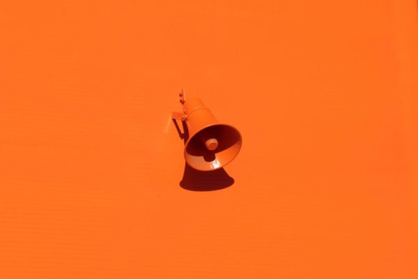 Kuvassa on oranssilla seinällä lähes saman värinen oranssi megafoni