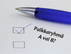 Kuvituskuva, jossa on valkoista taustaa vasten sininen kuulakärkikynä sekä kysymys "Palkaryhmä A vai B".